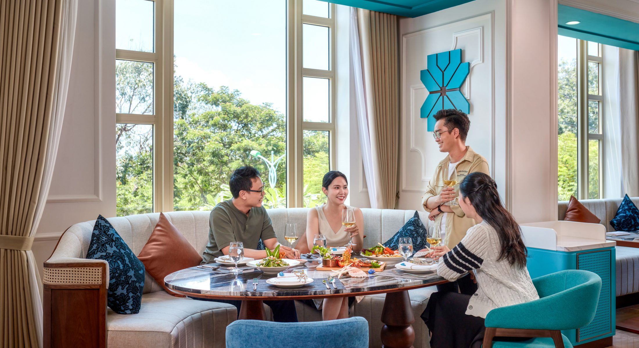 Guests dining at the hotel restaurant with natural light and coastal views