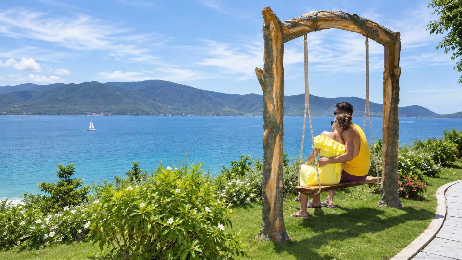Hai người ngồi trên xích đu gỗ nhìn ra biển xanh và núi ở Nha Trang
